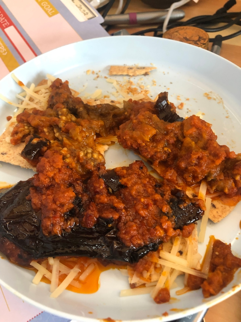 the result: the squichy eggplant spread on some crackers with shredded parm on top of the crackers and under the hot(temperature hot) eggplant to soften the cheese. It's all on a blue plastic kid's plate from Ikea that the sauce will probably stain. Should have thought of that.